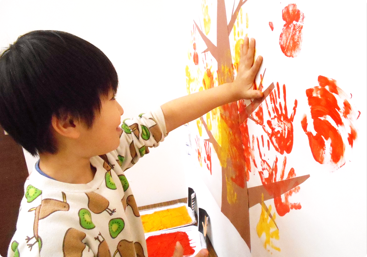 子どもが手を壁にかざしている写真