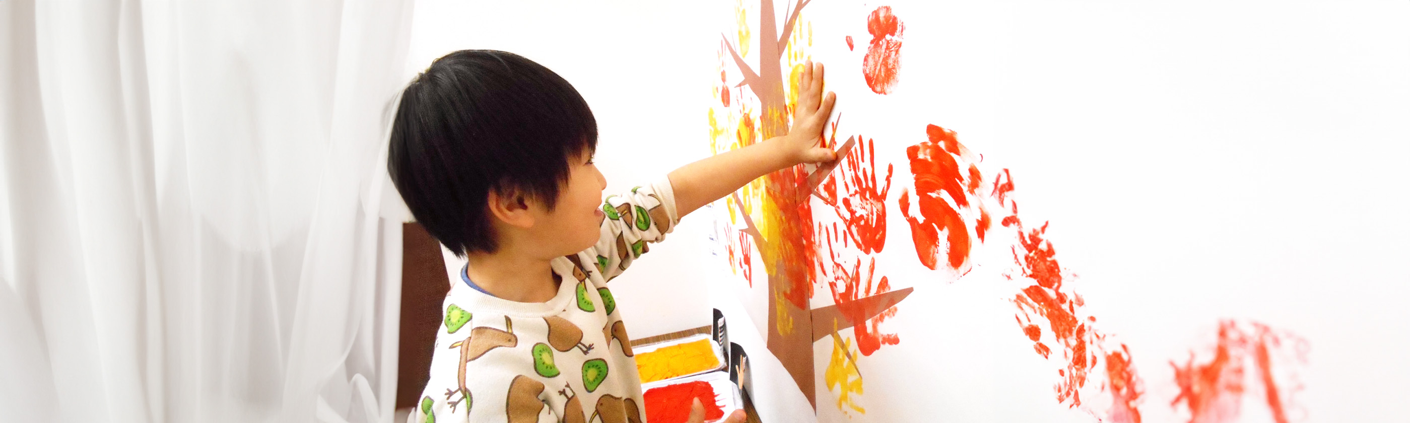 子どもが手を壁にかざしている写真