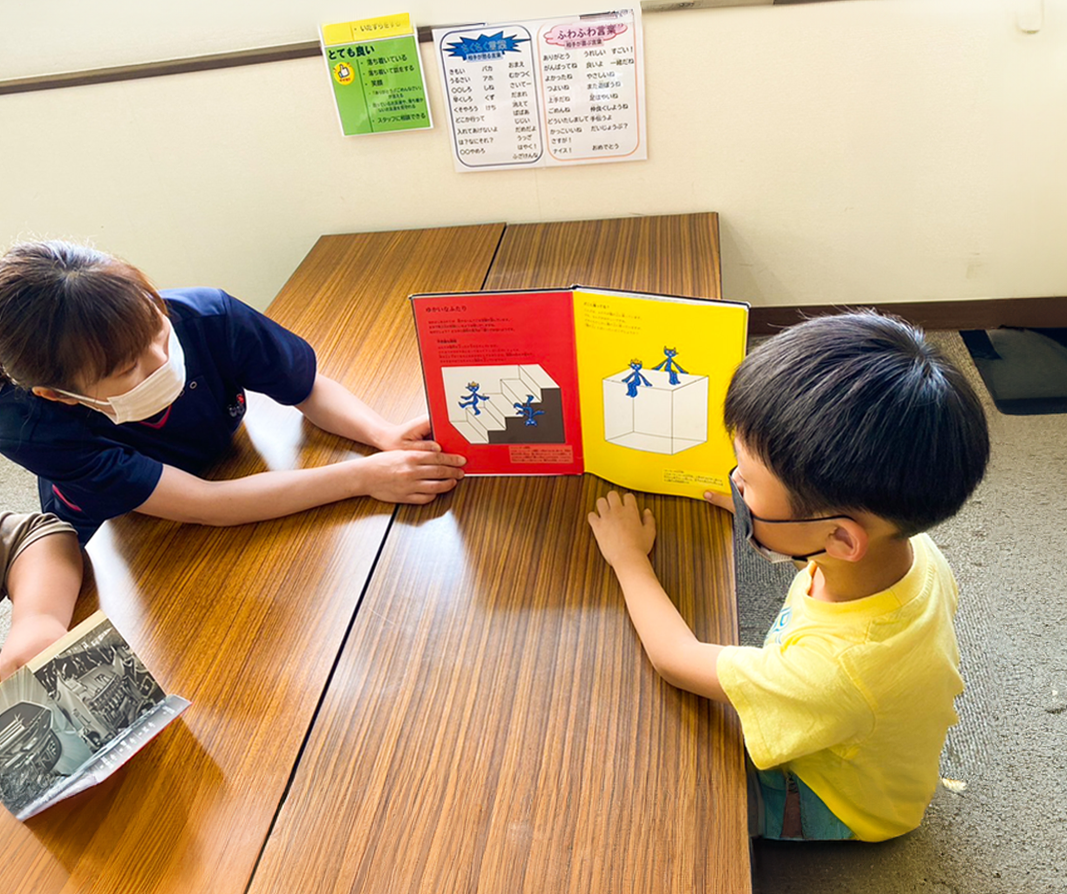 子供にスタッフが絵を見せている写真