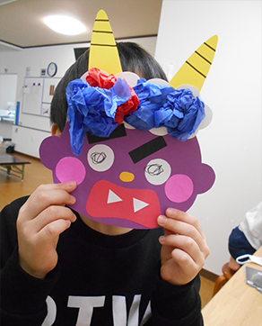鬼のお面を付けて遊んでいる子供の写真